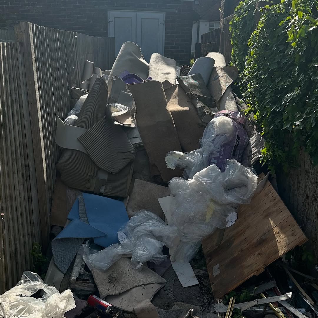 Carpets and household rubbish stacked outside โ house clearance before photo
